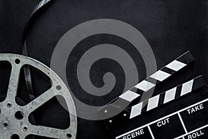 Watch film in cinema with video tape and clapperboard on black background top view