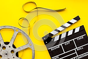 Watch film in cinema with video tape and clapperboard on yellow background top view