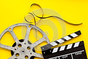 Watch film in cinema with video tape and clapperboard on yellow background top view