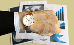 Watch on the left hand of business man  with data report background for business and financial