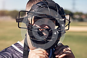 Watch me make baseball history. Portrait of a young man wearing a catchers helmet while playing a game of baseball.