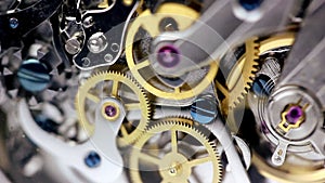 Watch mechanism clockwork with golden cogwheels and jewels running on silver steel internal closeup gear movement working with