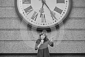 Watch the time concept woman in dark red dress next to huge watch over her head
