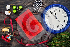 Watches, gifts, fir branches and decorations on a dark wooden background. Christmas composition. Christmas, winter, new year. Flat