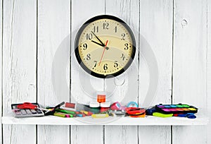 Watches and school tools on a wooden shelf.