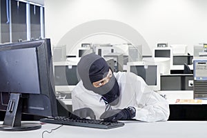 Watchful robber hacking computer in office