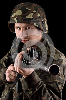 Watchful soldier aiming m16 in studio photo