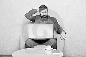 Watching blog for financial information. Businessman posting on online social network or blog at workplace. Bearded man