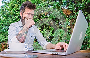 Watching blog for more information. Bearded man writing new blog post in summer cafe. Blogger keeping private blog