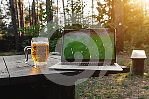 Watching a football match on a laptop outdoors in the forest