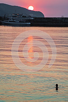 Watching the sunrise while swimming in the sea