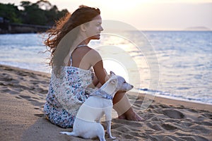Watching the sunset at the beach. an attractive young woman enjoying the beach with her dog.