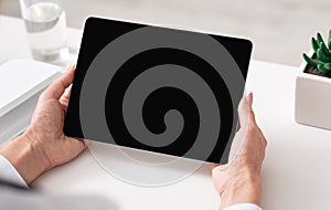 Watching video lesson or online webinar. Woman hands holds tablet with blank screen