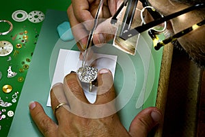Watchmaker with magnifying glasses repairs a wristwatch