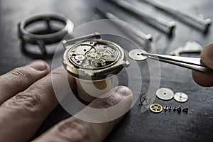 Watchmaker is repairing the mechanical watches in his workshop photo