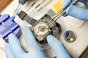 Watchmaker replacing battery in quartz watch, Watch maintenance service