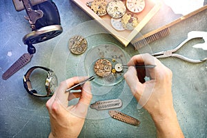 Watchmaker at work in workshop. Flat lay. Workplace of watch repairer. Process of repair mechanical watches.