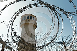 watchtower with barbed wire fence, security theme.