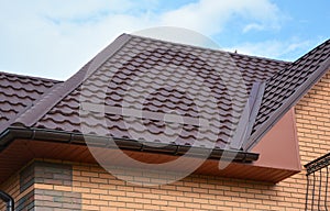 Wateproofing roof problem area with metal roof sheets and rain gutter. Lightweight metal roof tiles roofing construction