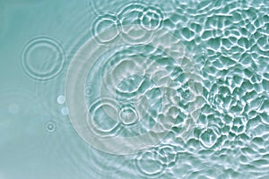 Water abstract background with blue rippled aqua texture, splash circle reflections in swimming pool. Top view