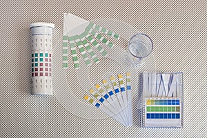 Water analysis kit, ph test strips and total hardness test strips and a test tube with water