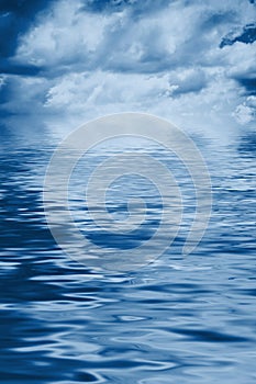 Water background with cloudy sky blue toned