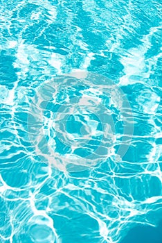 Water background, ripple waves. Blue swiming pool pattern. Sea surface. Water in swimming pool with sun reflection
