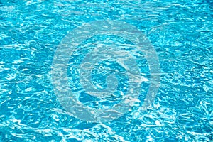 Water background, ripple waves. Blue swiming pool pattern. Sea surface. Water in swimming pool with sun reflection