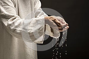 Water for Baptism pouring out of the hands of Jesus Christ