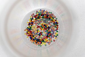 Water beads pearls in many different colours inside a circle transparent glass