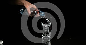 Water being poured into Glass against Black Background