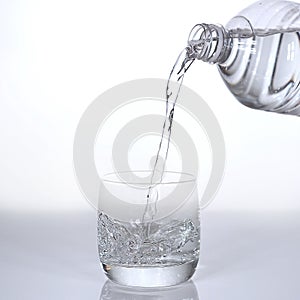 Water being poured into Glass against White Background