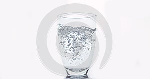 Water being poured into Glass against White Background