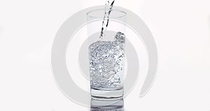 Water being poured into Glass against White Background