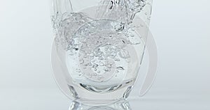 Water being poured into Glass against White Background