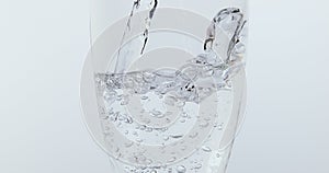 Water being poured into Glass against White Background