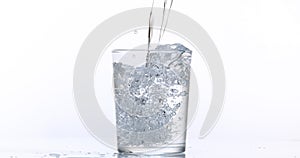 Water being poured into Glass against White Background