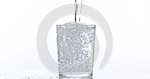 Water being poured into Glass against White Background