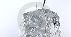 Water being poured into Glass against White Background