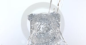 Water being poured into Glass against White Background