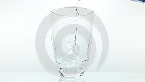 Water being poured into Glass against White Background,