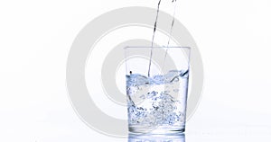 Water being poured into Glass against White Background,