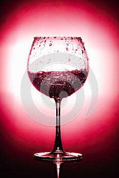 Water being poured into glass. isolated on bright red and black background