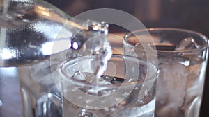 The water being poured of ice in glass with sensitive focus in the background.