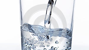 Water being poured near Glass against White Background