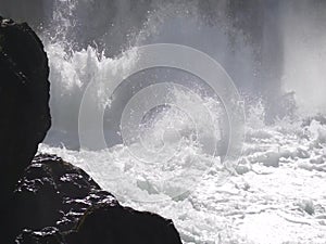 Water boiling in waterfall under old hydropower plant