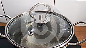 Water boils in a saucepan under the lid
