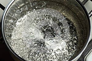 Water boils in a stainless steel pot. Boiling water