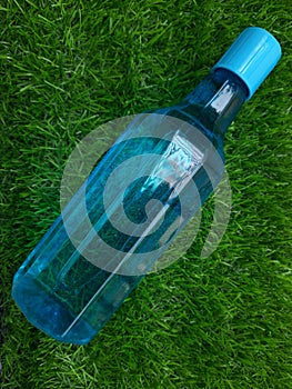 Water bottle on green grass as background