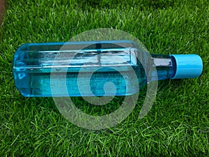 Water bottle on green grass as background